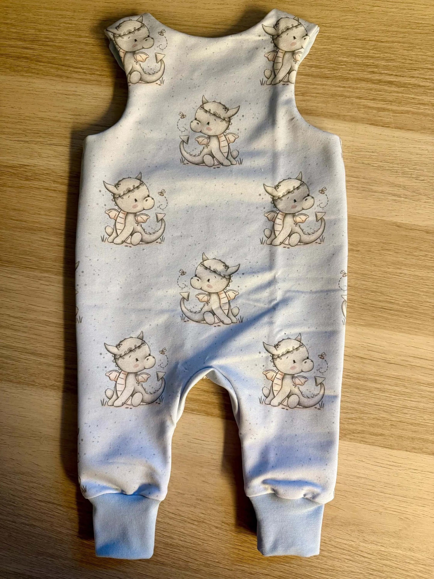 6. Baby trägt blauen Strampler Größe 62 mit Drachenmotiv im Kinderzimmer
