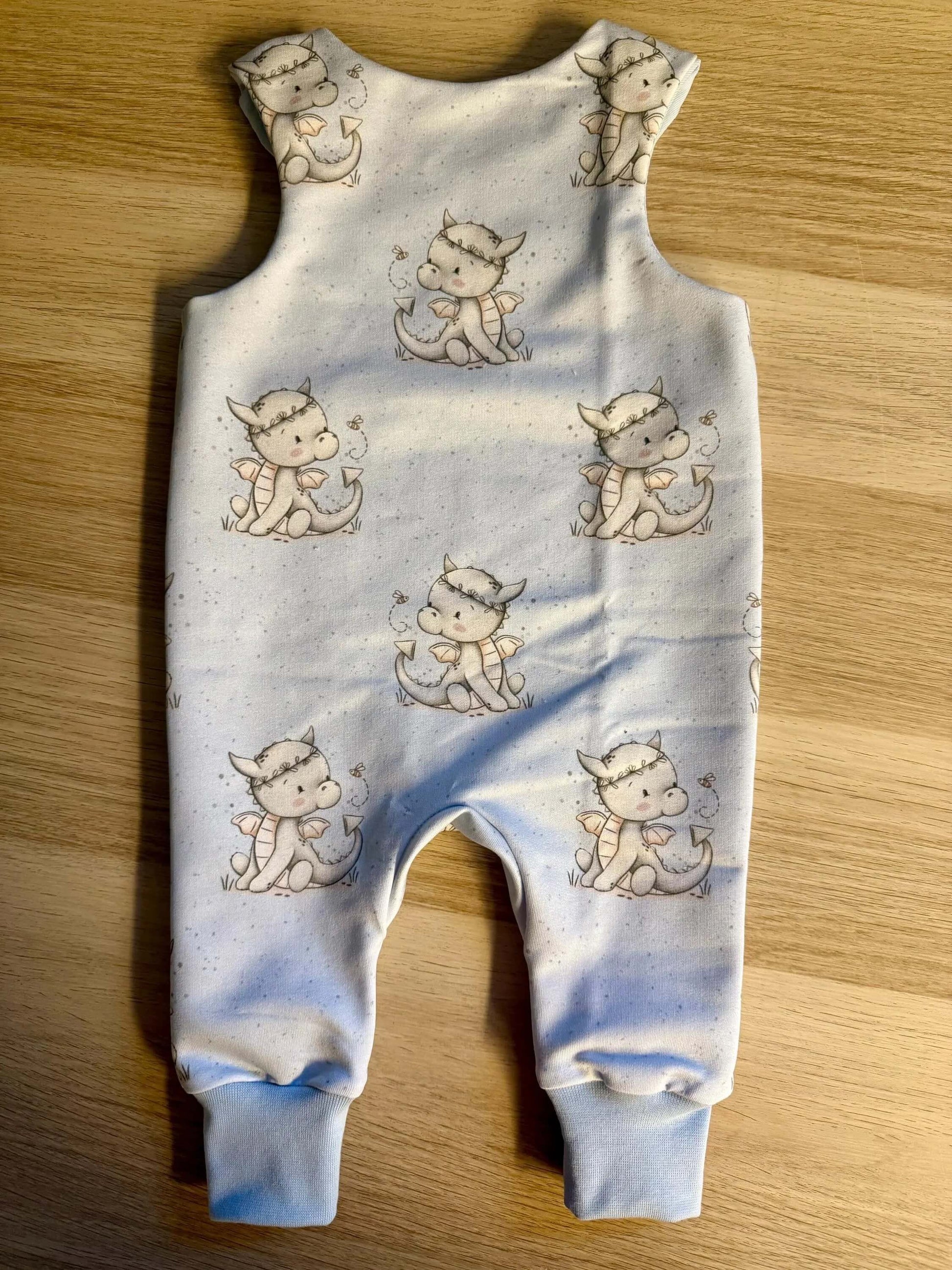 6. Baby trägt blauen Strampler Größe 62 mit Drachenmotiv im Kinderzimmer
