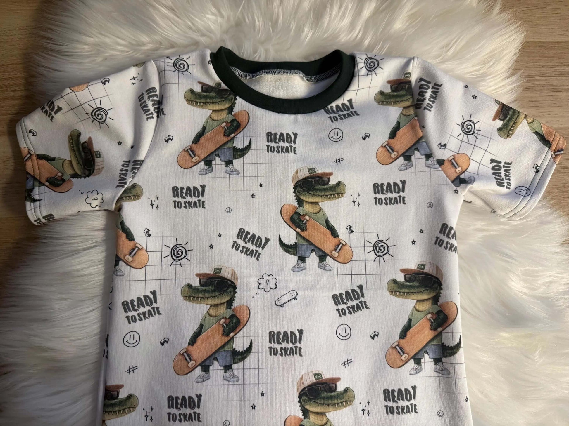 Alt-Text 1: Vorderansicht Kinder T-Shirt Skater Kroko auf Fell
