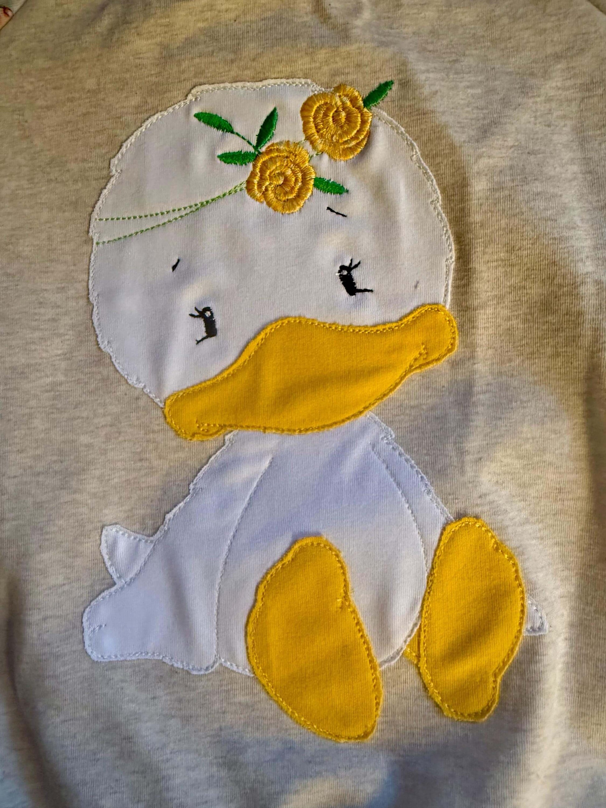 Detailaufnahme des Enten Stickbildes auf dem Pullover

