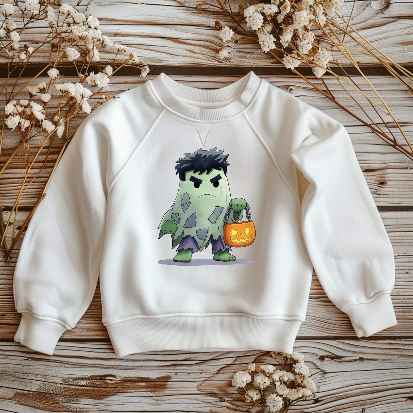 Buegelmotiv Gruenes Monster mit Geisterkostuem und Kuerbisbeutel