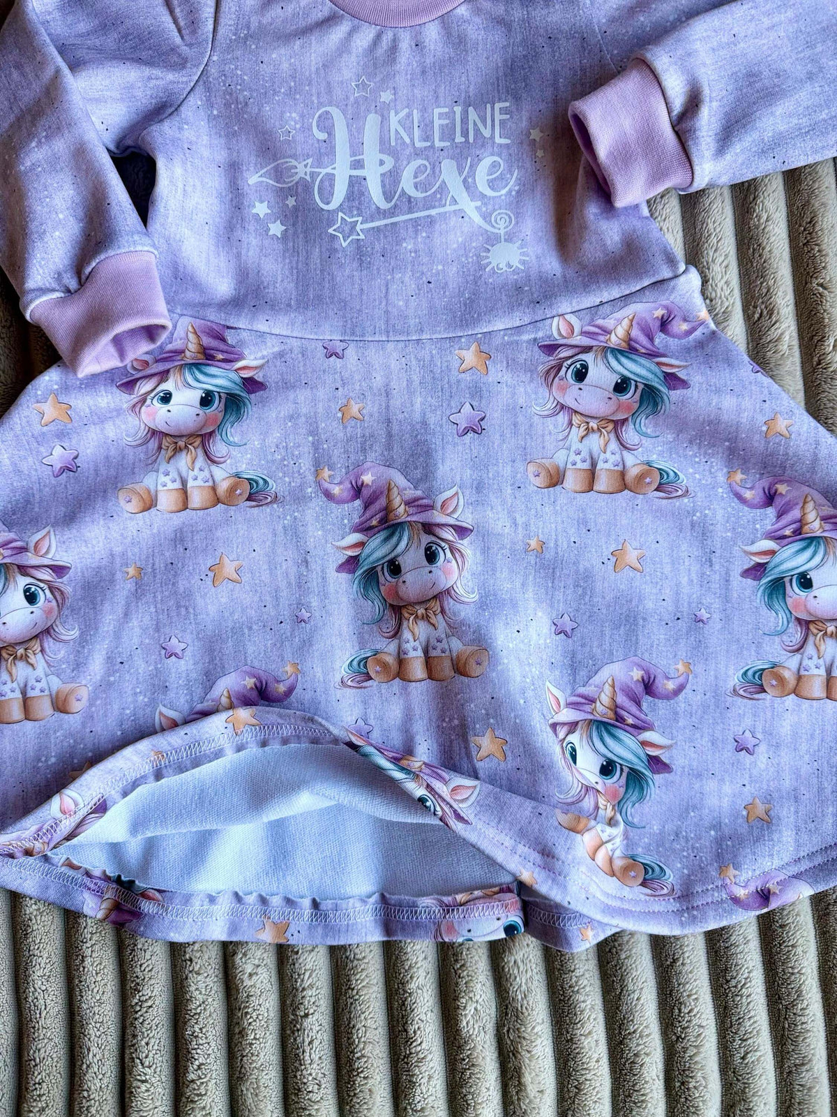 Kleid Kinder lila mit mittlerem Drehrock und Sternenzauber-Motiv, am Kleiderbügel fotografiert