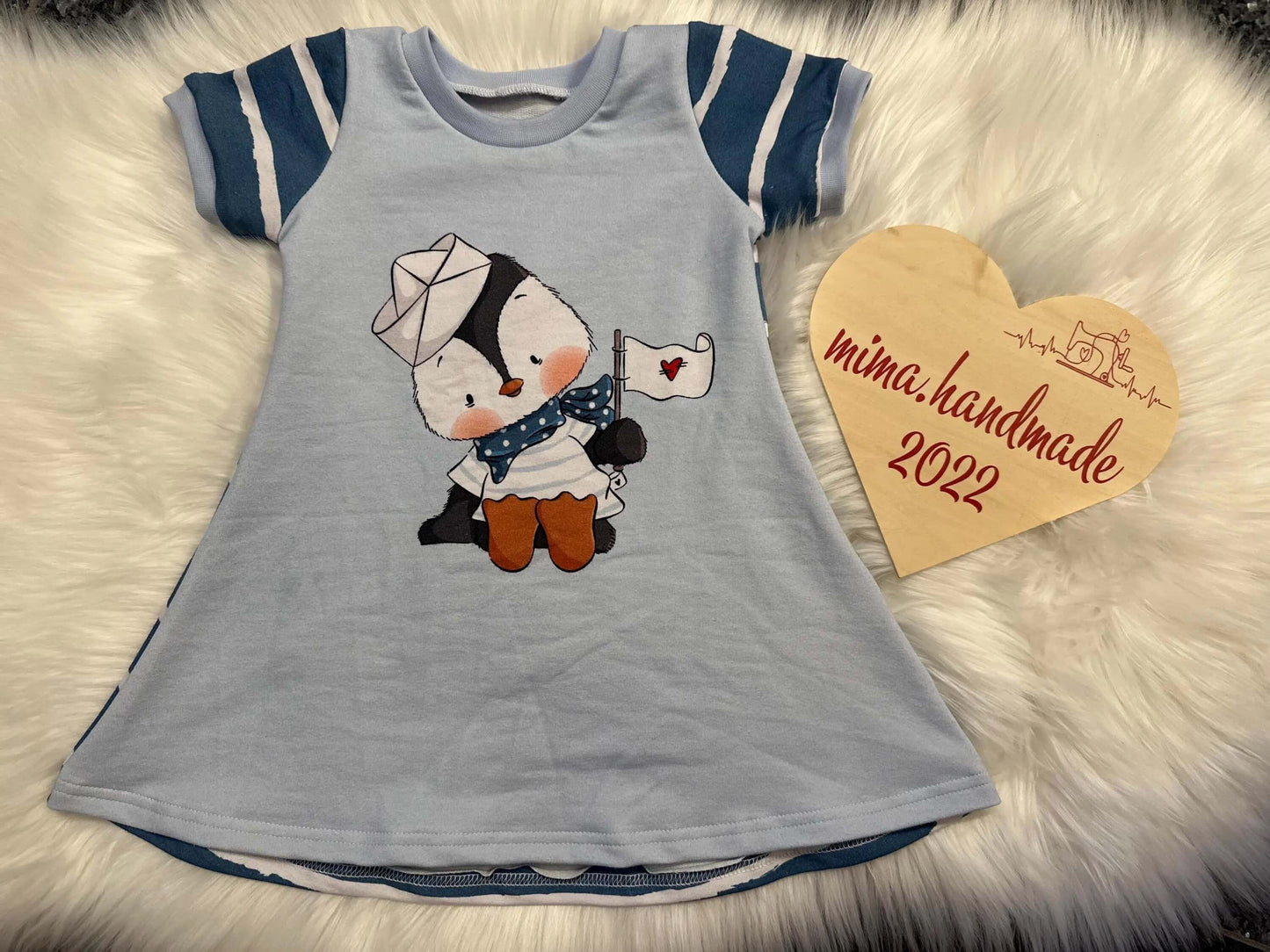 Handmade Kinderkleid Pinguin auf Fell Hintergrund Vorderansicht
