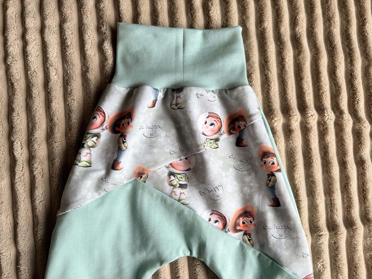 Pumphose Kinder Größe 98 grün mit Spielzeugfreunde-Muster und Bauchbündchen, flach liegend fotografiert