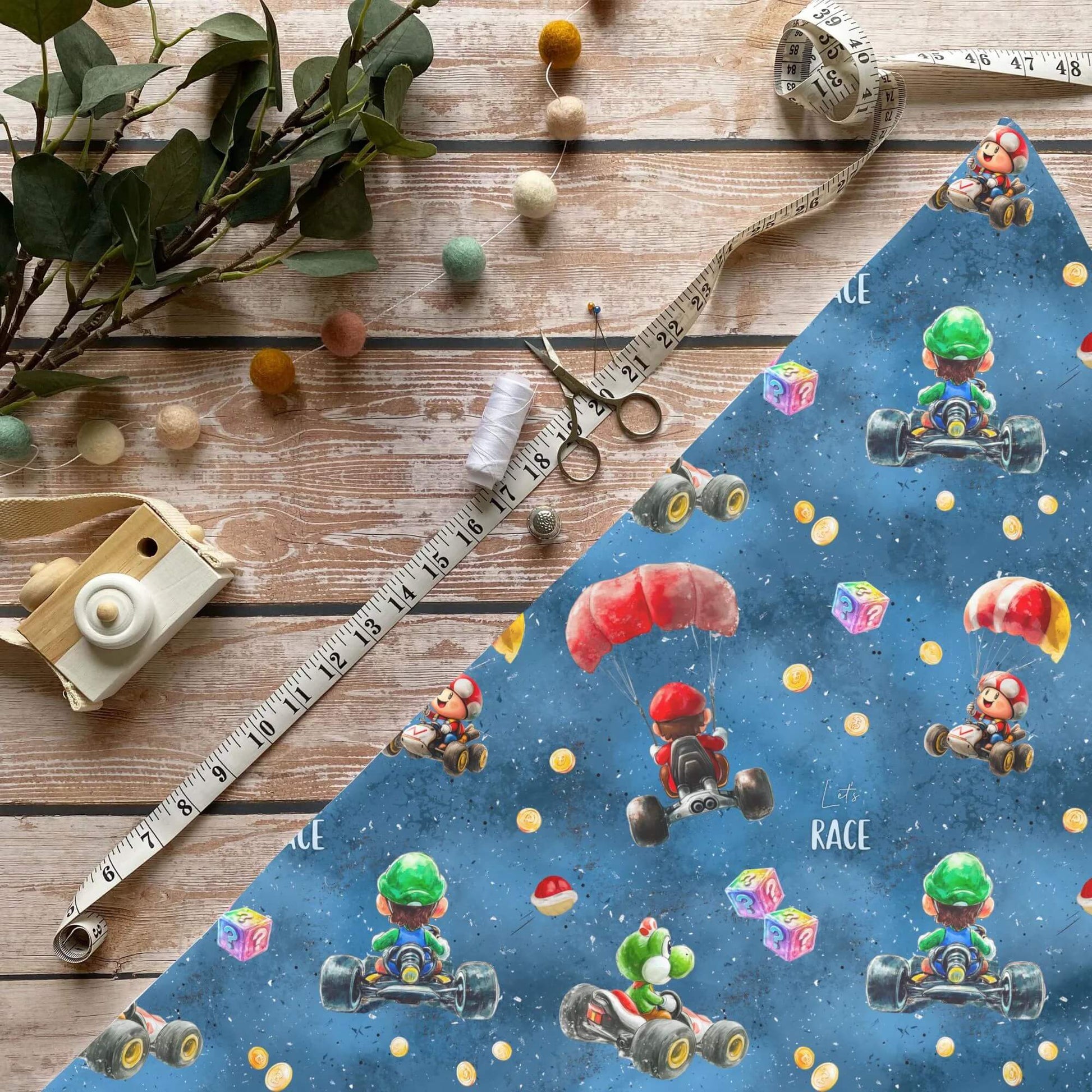 Fallschirmflitzer Baumwollstoff mit Rennmotiv und bunten Figuren auf blauem Hintergrund