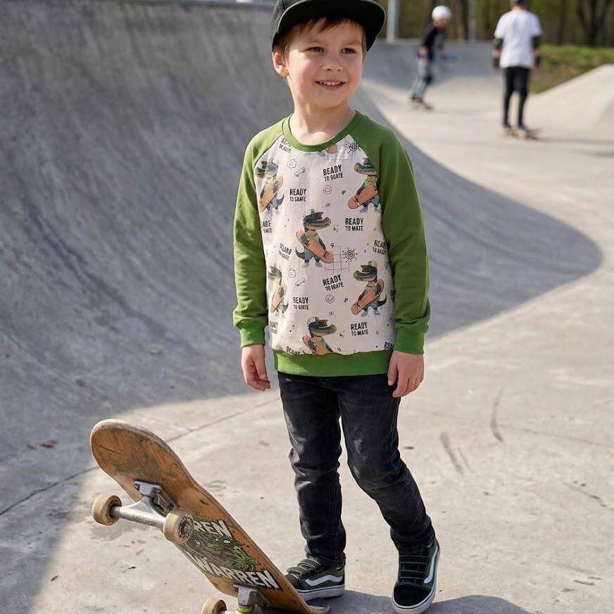 Grüner Kinder Raglan Pullover Gr. 122 mit Skater-Kroko-Muster, Styling-Foto mit Eukalyptuszweig