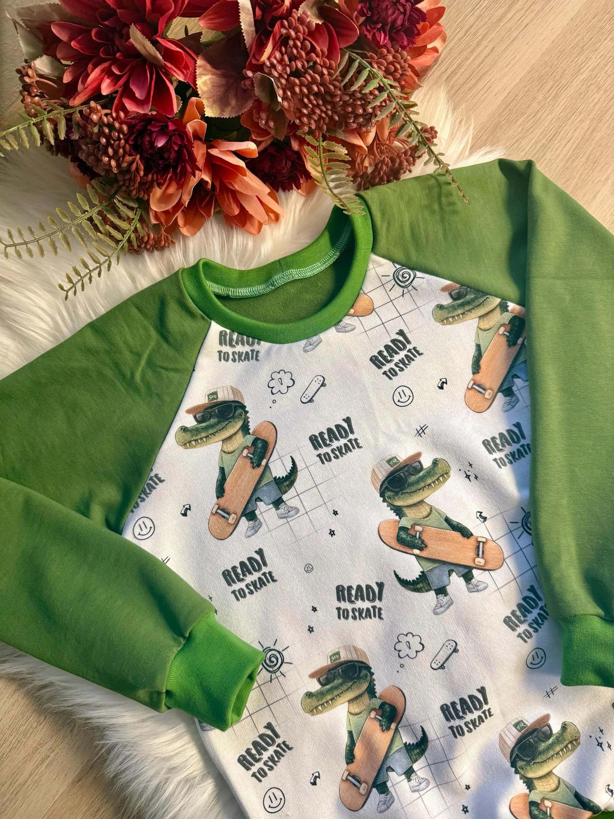 Detailansicht grüne Bündchen am Halsausschnitt des Kinder Raglan Pullovers Skater Kroko