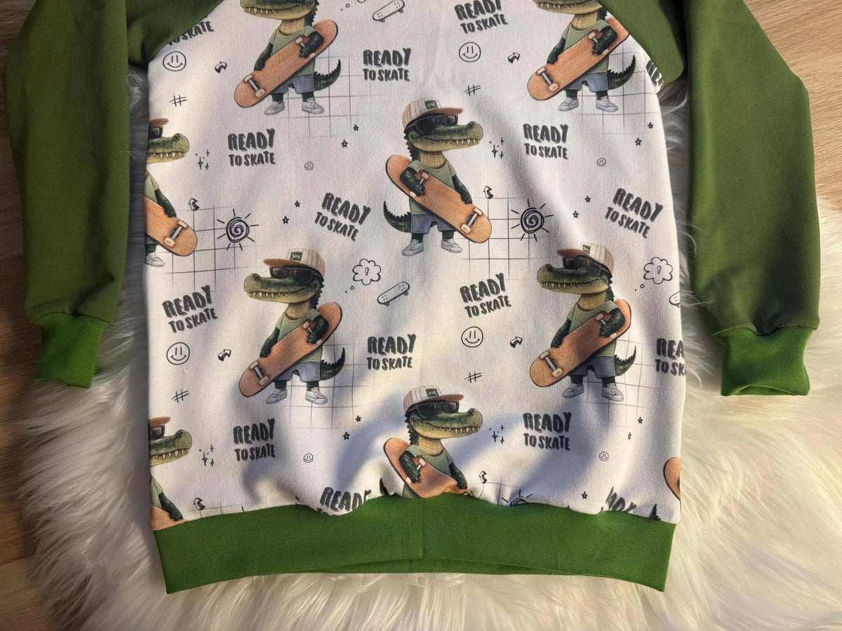 Nahaufnahme grünes Ärmelbündchen am French Terry Kinderpullover Skater Kroko Gr. 122
