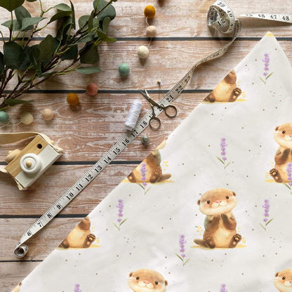 Otter Baumwollstoff mit Tiermotiv und Lavendelblüten auf hellem Hintergrund