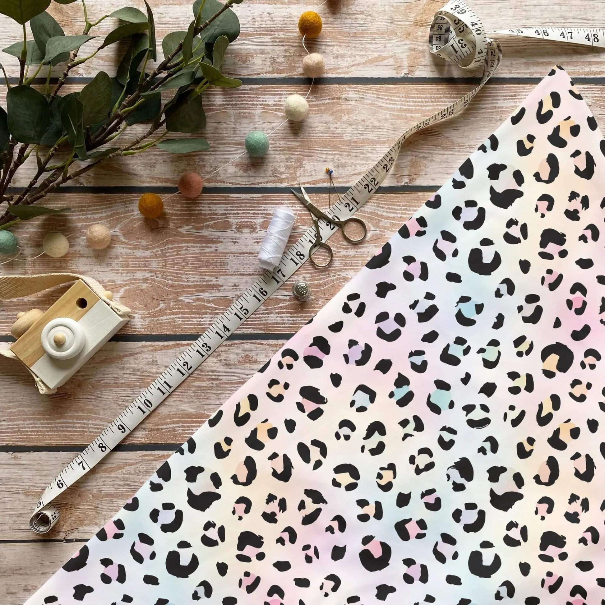 Regenbogen Leo Flecken Jersey Stoff mit Animalprint auf pastellfarbenem Hintergrund