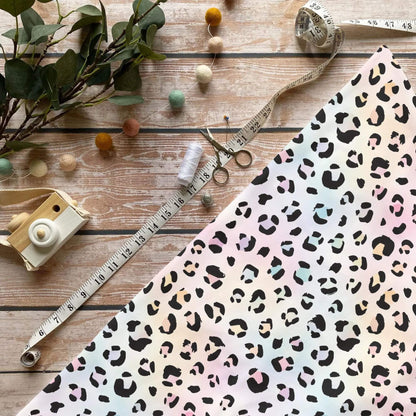 Regenbogen Leo Flecken Jersey Stoff mit Animalprint auf pastellfarbenem Hintergrund