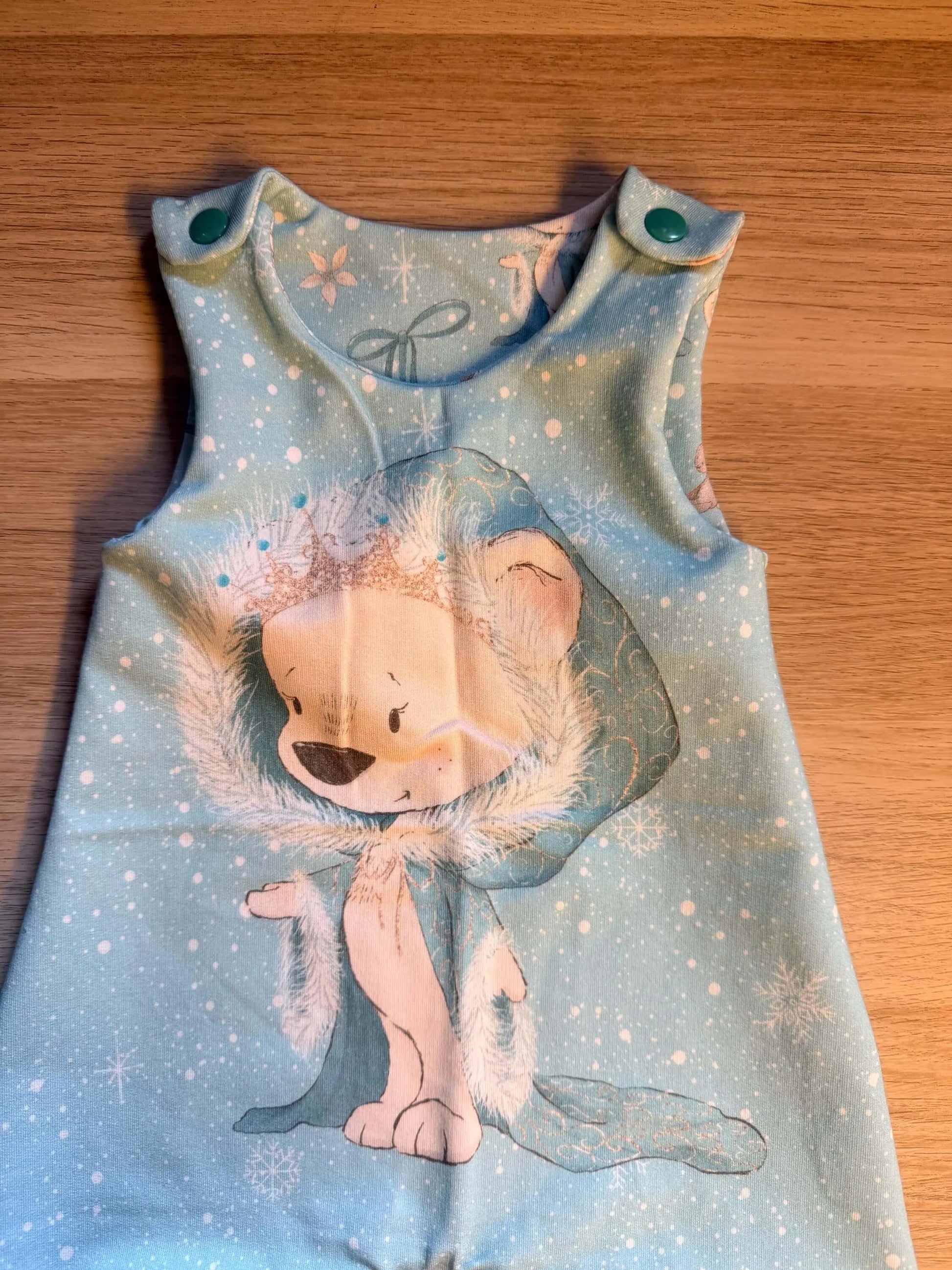Baby Strampler mit Eisbärmotiv, flach liegend fotografiert
