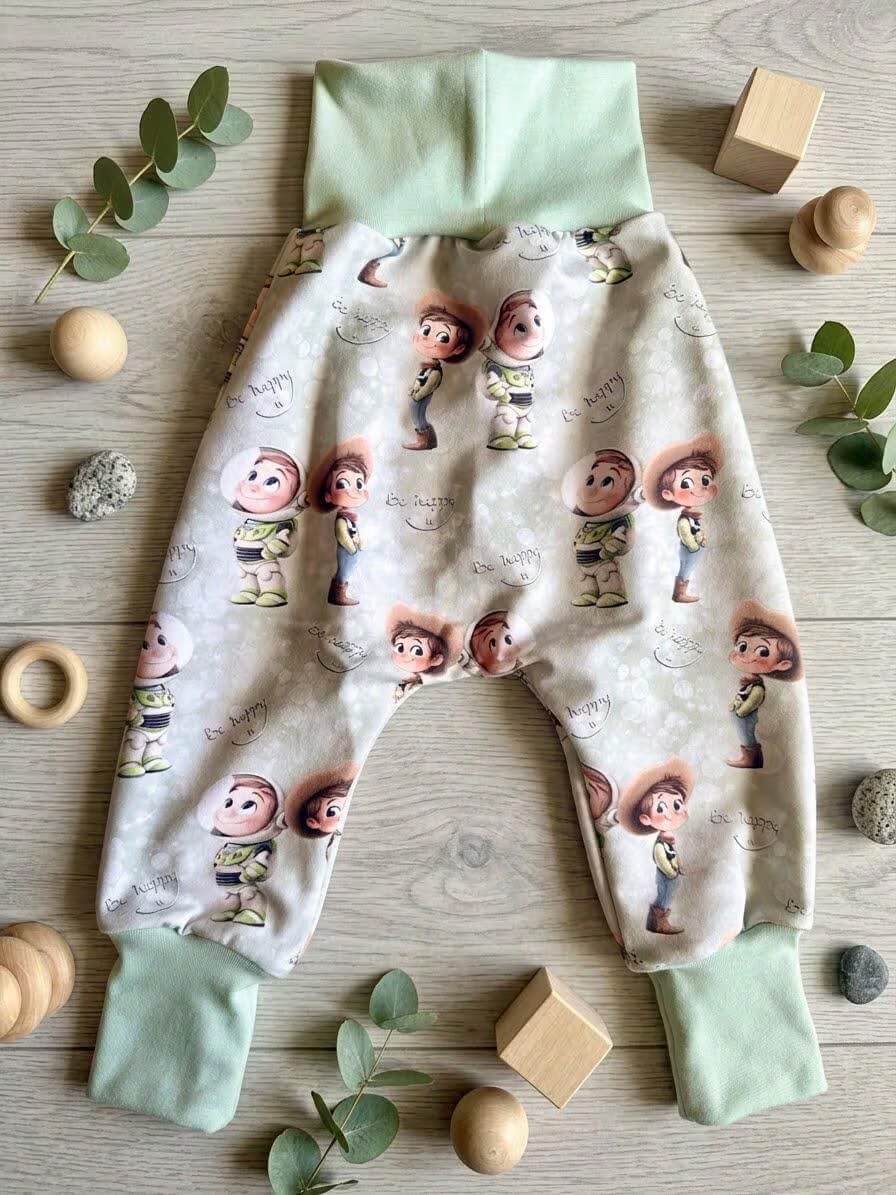 Pumphose Baby grün mit Spielzeugfreunde-Eigendesign, French Terry, mit Holzdeko und Eukalyptus fotografiert