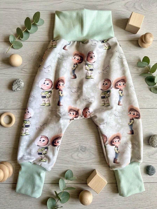 Pumphose Baby grün mit Spielzeugfreunde-Eigendesign, French Terry, mit Holzdeko und Eukalyptus fotografiert