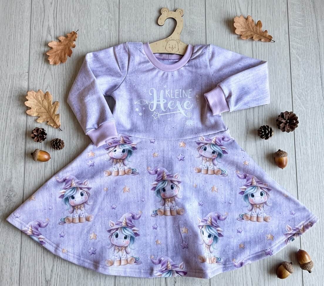 Kleid Kinder lila mit Sternenzauber-Eigendesign und Bügelbild Kleine Hexe, French Terry, mit Herbstdeko fotografiert