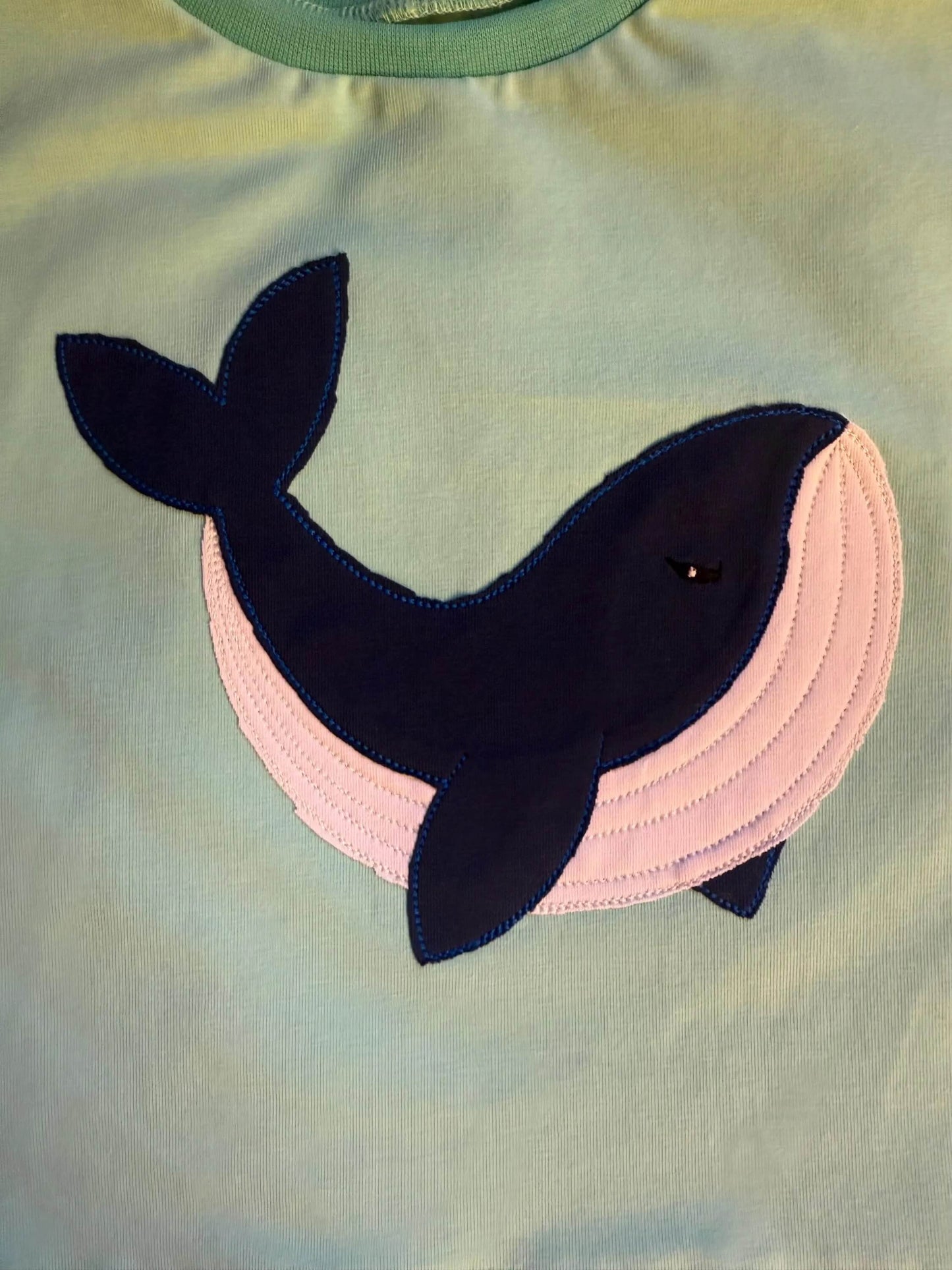 Detailaufnahme des Wal‑Stickbildes auf dem Shirt
