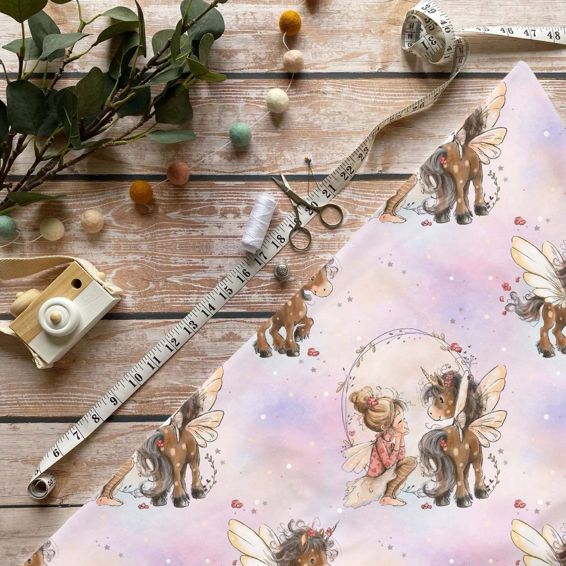 Fee mit braunem Einhorn Stoff Meterware mit märchenhaftem Design auf Pastellhintergrund
