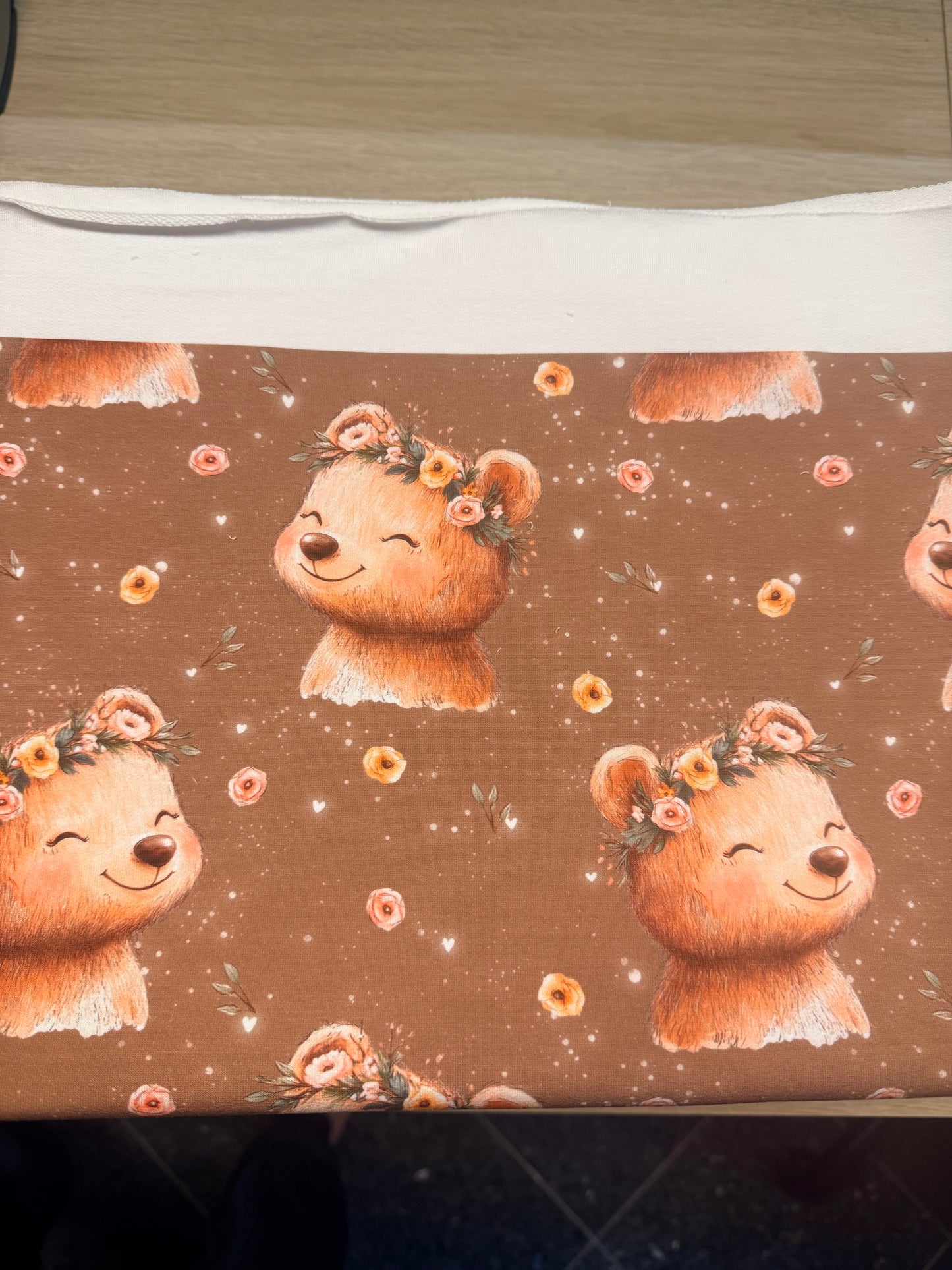 Bär mit Blumen French Terry Stoff mit braunem Hintergrund und floralen Details