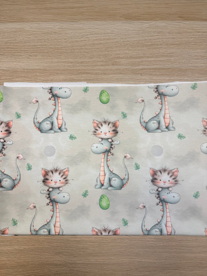 Dino mit Katze Jersey Stoff mit wolkigem Hintergrund und grünen Eiern