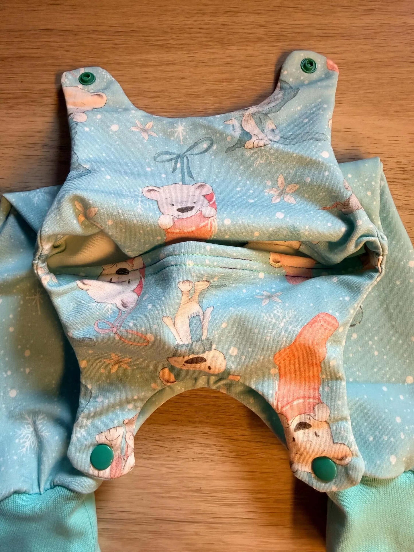 Detailaufnahme des Eisbärstoffmusters auf blauem Baby Strampler
