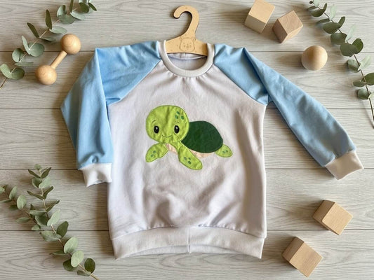 Pullover Kinder Größe 98 blau mit Schildkröten-Stickapplikation, Jersey, mit Holzdeko fotografiert