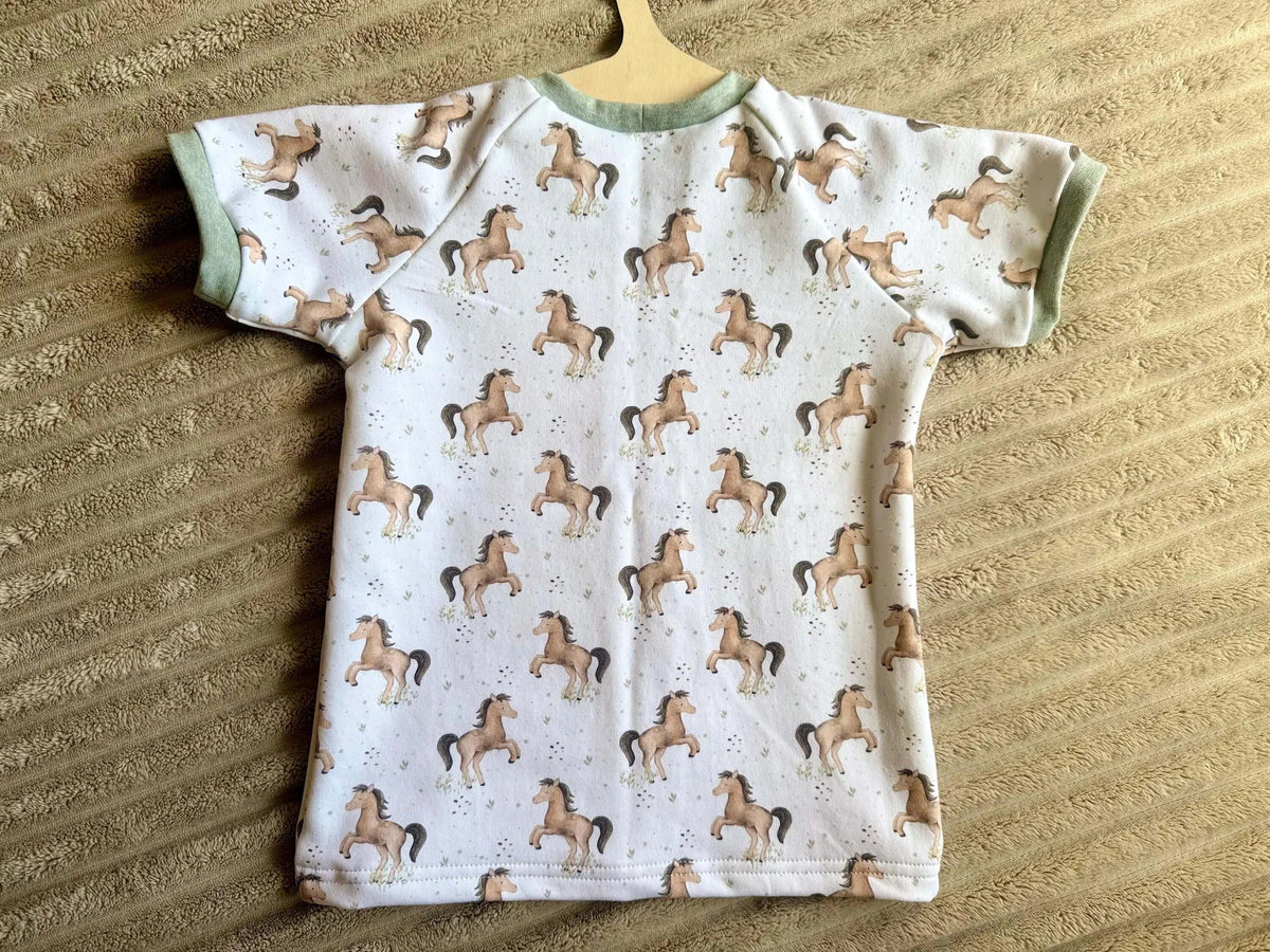 Nahaufnahme grünes Armbündchen am French Terry T-Shirt Kleine Pferde Gr. 98