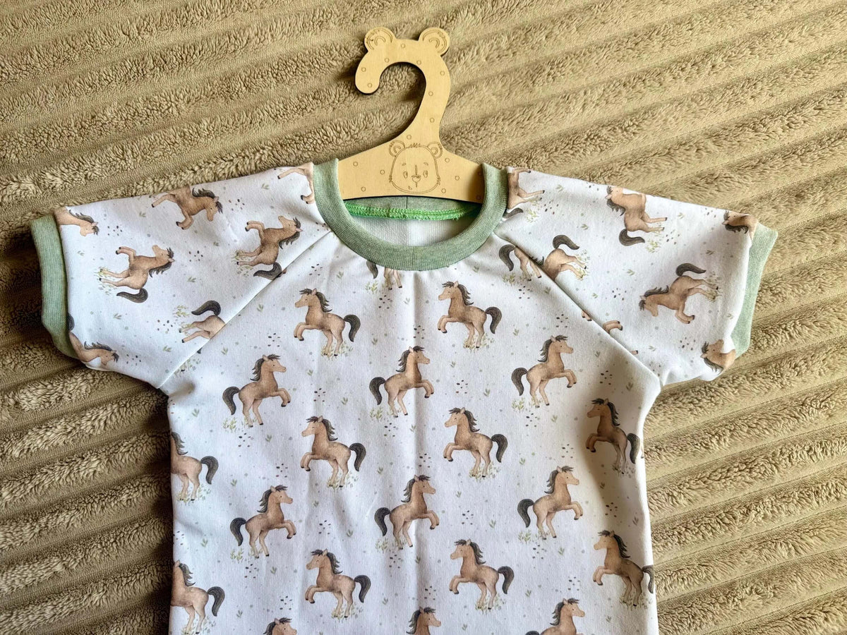 Weißes Kinderset Raglan Shirt und Rock Gr. 98 mit Pferdemotiv, Styling-Foto mit Eukalyptus und Holzdeko