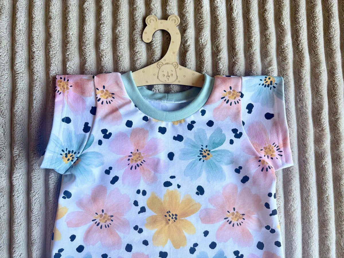 Nahaufnahme umgeschlagener und coverlockvernähter Ärmelabschluss am Jersey T-Shirt Gr. 122